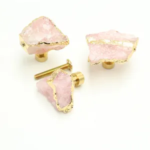 Detailed macro view of pink crystal stone knobs with brass base and mounting screws
