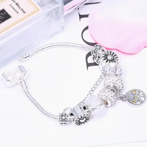 Silver snake chain charm bracelet with crystal beads and life tree pendant on white base