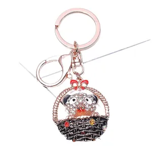 Llavero de oso en cesta de oro rosa con lazo rojo y cristales de colores brillantes