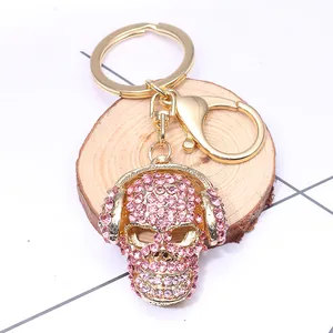 Pink rhinestone skull keychain with headphones on a golden base and lobster clasp