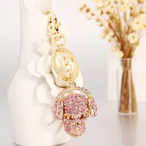Pink rhinestone skull keychain with headphones and gold-tone lobster clasp for bags