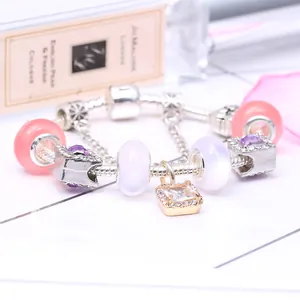 Bracelet à breloques argenté avec perles roses et pendentif diamant sur fond floral