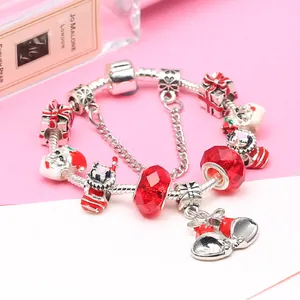 Bracelet de Noël avec perles de cristal rouge et cloche argentée sur fond élégant