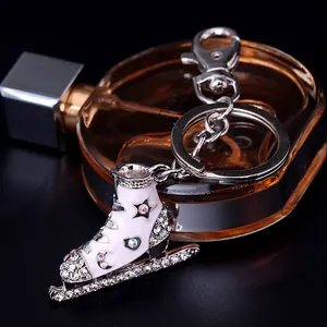 Porte-clés patin à glace blanc avec strass argentés et détail d'étoile sur fond noir