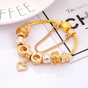 Golden charm bracelet with heart pendant, yellow glass beads and crown charms