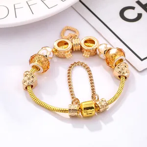 DIY gold heart charm bracelet with crown beads and orange faceted crystal on snake chain