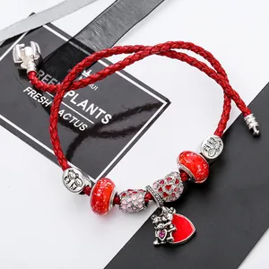 European charm bracelet with red woven cord, silver beads, and heart pendant with hugging bears