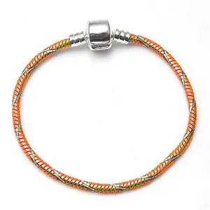 Macro detail of 3mm DIY snake chain bracelet featuring colorful orange and green spray paint