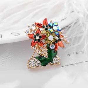 Détail d'une broche botte de Noël en émail vert avec strass colorés sur alliage doré