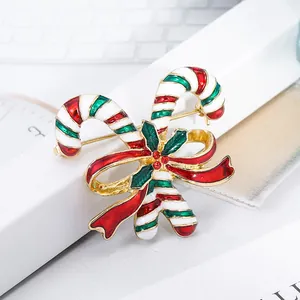 Christmas candy cane brooch with red bow and green leaves in colorful enamel finish