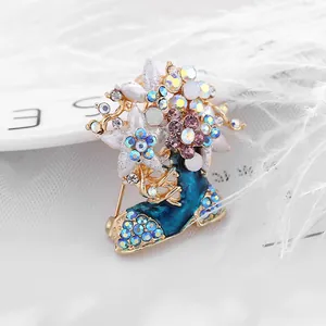 Détail de la broche botte fleurie en émail bleu avec des cristaux étincelants