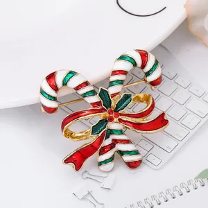 Christmas candy cane brooch with red bow and green holly leaves on gold alloy base