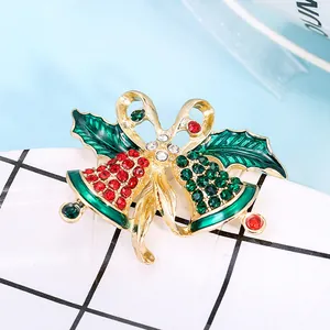 Elegant Christmas bell brooch with red crystals and green enamel leaves on gold metal