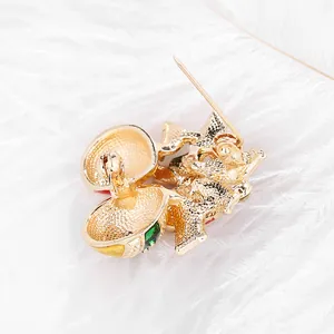Broche de árbol de Navidad dorado con gemas de colores y pasador sobre plumas blancas