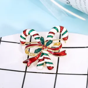 Christmas candy cane brooch with festive red bow and green enamel holiday details