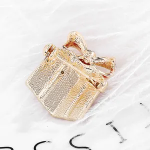 Golden gift box brooch with festive bow shown from the detailed back pin view
