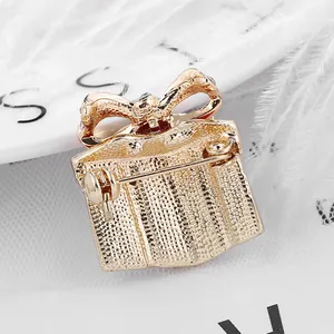 Golden gift box brooch with hammered metal texture and secure back pin closure