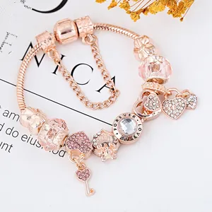 Roségoldenes Damenarmband mit Herz- und Schlüsselanhänger sowie rosa Kristallperlen