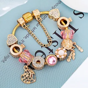 Bracelet à breloques en maille serpent dorée avec cristaux roses et pendentifs cœur élégants