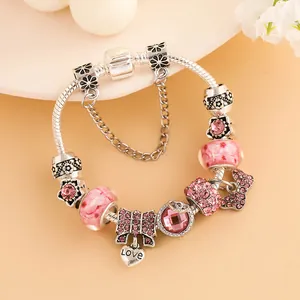 Bracelet à breloques argenté avec nœud en strass rose et pendentif cœur gravé Love
