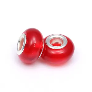 Vue détaillée de deux perles acryliques rouges translucides avec noyaux en métal argent