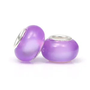 Gros plan de deux perles charm en acrylique violet translucide avec cœurs en argent