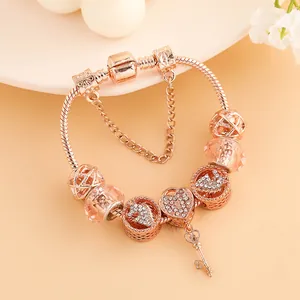 Elegantes rotgoldenes Schlangenarmband mit Herzanhängern und einem feinen Schlüssel