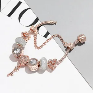 Bracciale a serpente oro rosa con ciondoli a cuore e un dettaglio a forma di chiave