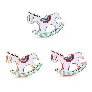 Trois charms cheval à bascule en argent, or et or rose avec détails de selle émaillés