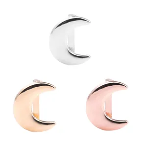 Trois breloques en forme de lune en argent, or et or rose au fini métallique