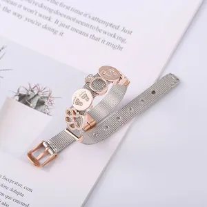 Mesh keeper bracelet with rose gold baby feet and paw charms on white magazine