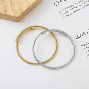 Gold and silver stainless steel twisted cable bracelets in an open-cuff elastic design