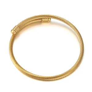 Detail view of the gold stainless steel cable bracelet with textured ball terminals
