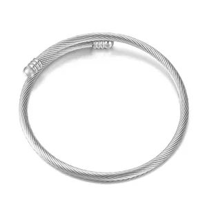 Silver stainless steel cable twisted bracelet with spherical finials on white background
