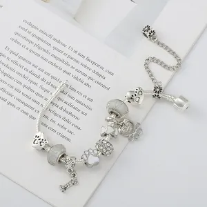 Zilveren bedelarmband met hondenpootafdrukken en botbedeltjes aan een slangenketting
