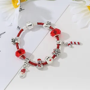 Dettaglio del bracciale di Natale con ciondoli Babbo Natale su cordoncino rosso