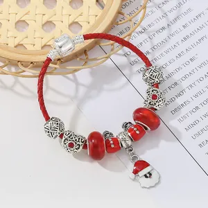 Dettaglio del bracciale natalizio fai-da-te con cordino in pelle rossa e ciondolo Babbo Natale