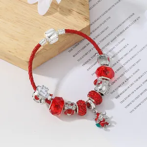 Dettaglio del bracciale in pelle intrecciata rossa con ciondoli argentati e smaltati