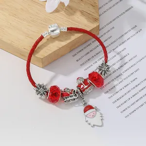 Dettaglio del braccialetto natalizio in pelle rossa con ciondoli Babbo Natale e fiocchi