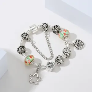 Silbernes Perlenarmband mit grünen Glasperlen und Lebensbaum-Anhängern im Blumendesign