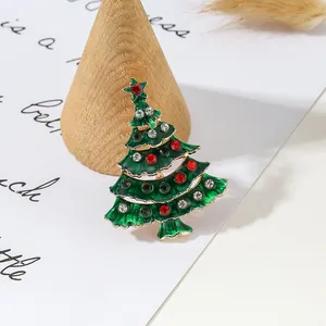 Classic Christmas tree brooch with green enamel and colorful rhinestones on white background