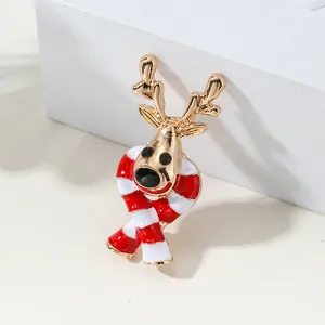 Christmas reindeer brooch with gold plating and red striped scarf on a white pedestal