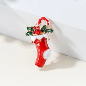 Christmas stocking brooch with candy cane and red rhinestones on a white pedestal