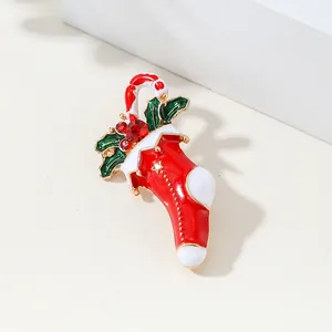 Festive Christmas brooch with enamel red stocking, candy cane, and holly leaf accents