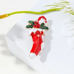 Christmas stocking brooch with holly leaves and candy cane on a white gift box