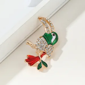 Broche de perroquet de Noël avec émail vert et strass étincelants sur base dorée