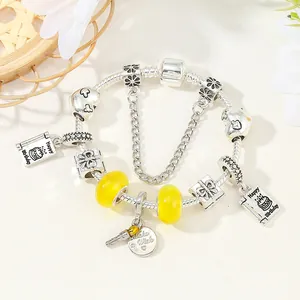 Charmantes silbernes Perlenarmband mit gelben Glasperlen und Geburtstagsanhängern