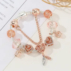 Charm armband in roségoud en zilver met hartje, kroon en veer hangers voor dames