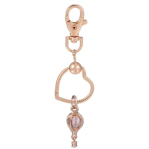 Porte-clés en or rose avec cadre en cœur et pendentif montgolfière violette