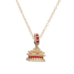 Détail d'un collier chaîne serpent doré avec un pendentif de palais chinois rouge